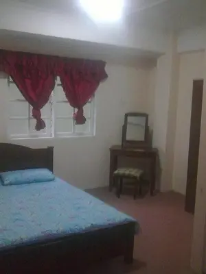 a bedroom with a bed and a table and a mirror at Cameron Highland 3 Bedroom Apartment in Cameron Highlands