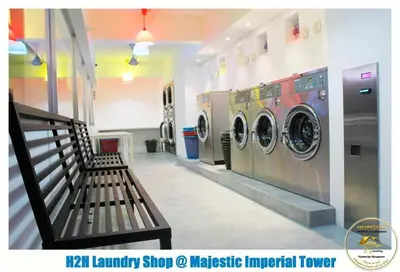 a laundry room with two washing machines and a bench at Heart of Town Free WIFI -Majestic Ipoh By Hopestay in Ipoh