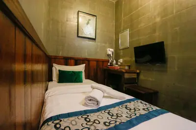 a small bedroom with a bed and a television at Anggun Hotel in Seri Iskandar