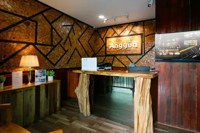 a restaurant with a table in a room with wooden walls at Anggun Hotel in Seri Iskandar