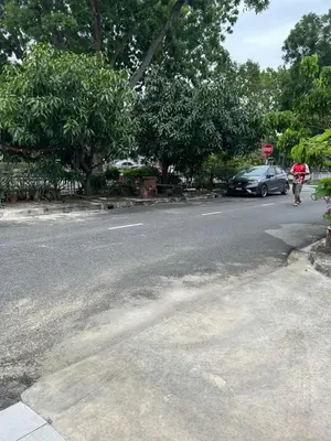 a person walking down a street with a stop sign at Comfortable two-storey terrace house near main road perai in Perai