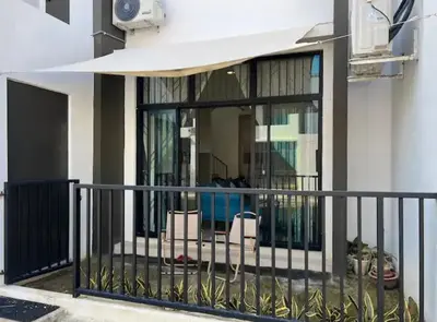 a balcony with two chairs and a window at Casa Home Homestay Lunas in Lunas