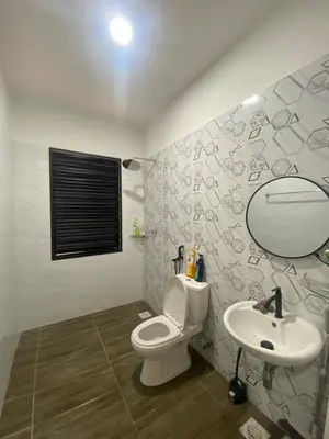 a bathroom with a toilet and a sink and a mirror at Cozy Homestay, Tasek Idaman Town, Batu Gajah in Batu Gajah