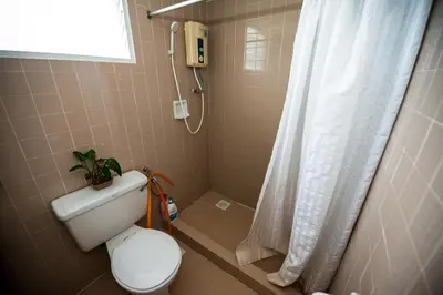 a bathroom with a toilet with a shower curtain at Jean CleanComfy Apt Near Beach in Batu Ferringhi