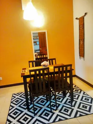 a dining room with a table and chairs on a rug at Jean CleanComfy Apt Near Beach in Batu Ferringhi