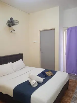 a bedroom with a large bed with a fan on it at Netasha Holiday INN in Tanah Rata