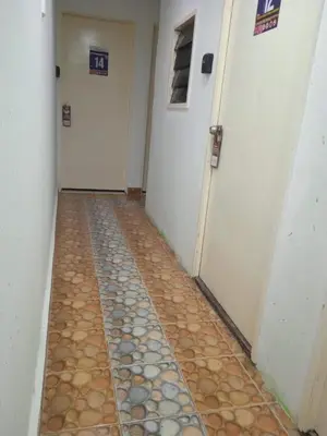 a hallway with two white doors and a tile floor at Netasha Holiday INN in Tanah Rata