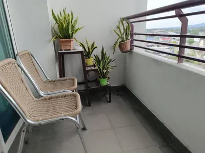 a balcony with two chairs and plants and a window at Heart of Ipoh 2BR 6pp in Ipoh