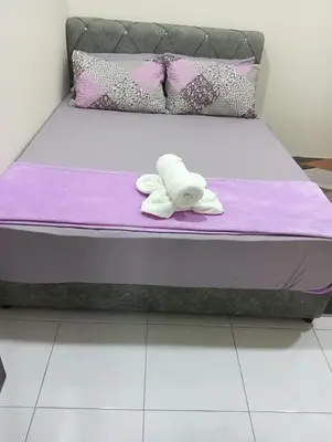 a bed with a towel on top of it at REZEKI MUEZZA 3BR2B Cozy Homestay in Teluk Intan