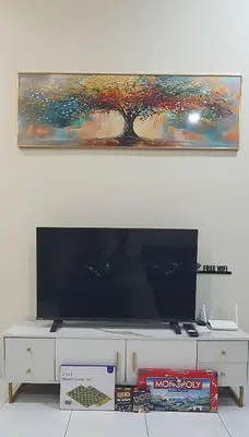 a large flat screen tv sitting on top of a white cabinet at REZEKI MUEZZA 3BR2B Cozy Homestay in Teluk Intan