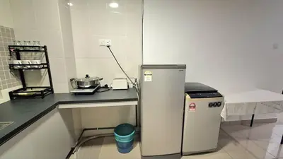 a kitchen with a counter and a refrigerator in a room at A well-kept unit with four bedrooms and ensuite bathrooms in Kampar