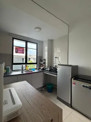 a kitchen with a refrigerator and a table in it at A well-kept unit with four bedrooms and ensuite bathrooms in Kampar