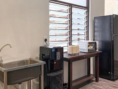 a kitchen with a desk with a sink and a refrigerator at Love Linn in George Town