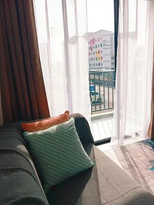 a couch in a living room with a large window at Radif Homestay Seri Iskandar with Balcony#2 in Kampong Bota Road