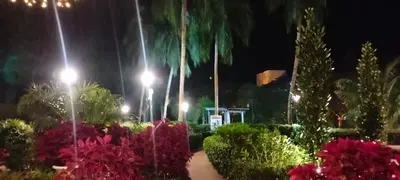 a garden at night with palm trees and flowers at Sri Sayang Batu Ferringhi 4 Bed in Batu Ferringhi