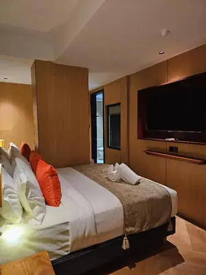a bedroom with a large bed with a flat screen tv at The Green Hall in George Town