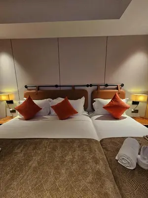 a large bed with orange and white pillows on it at The Green Hall in George Town