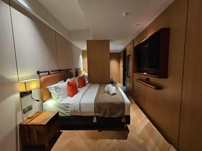 a hotel room with a bed and a flat screen tv at The Green Hall in George Town