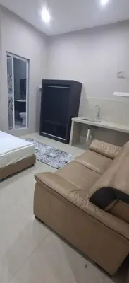 a bedroom with a couch and a flat screen tv at Cozy Nook in George Town