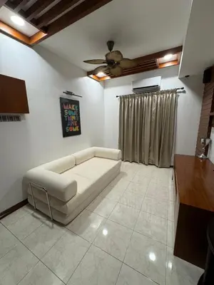a living room with a couch and a ceiling fan at Ichinichi Home in Ipoh