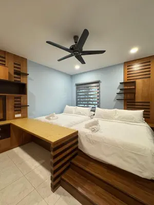 a bedroom with a large bed with a ceiling fan at Ichinichi Home in Ipoh