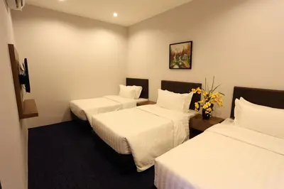 a hotel room with two beds with white sheets at S Boutique Hotel in Ipoh