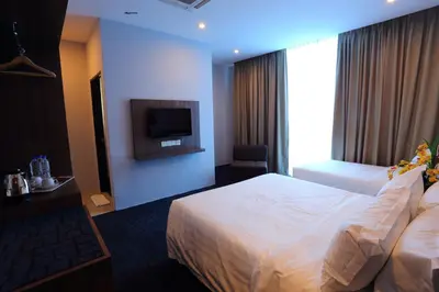 a hotel room with two beds and a television at S Boutique Hotel in Ipoh
