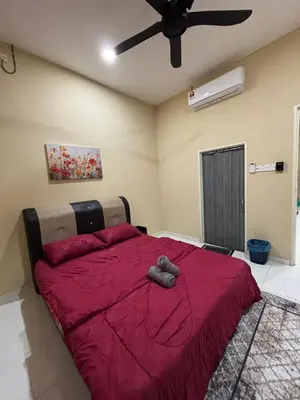 a bedroom with a red bed with a ceiling fan at Welcome To Amda CS Guest House