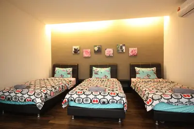 two beds in a room with pictures on the wall at Shamrock Beach Villas 15 Seaview in George Town