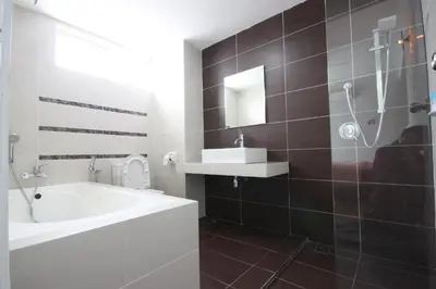 a bathroom with a tub and a sink and a shower at Shamrock Beach Villas 9 Seaview in George Town