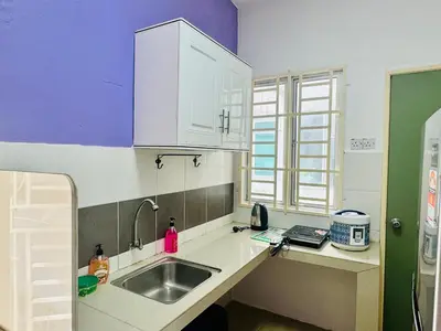 a kitchen with white cabinets and a sink at AYAAN LAVENDER Homestay with PS4 Gaming and Netflix at Tanah Rata Cameron Highland in Tanah Rata