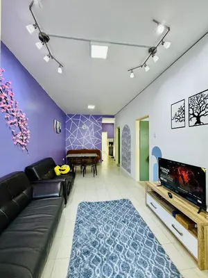 a living room with a couch and a tv at AYAAN LAVENDER Homestay with PS4 Gaming and Netflix at Tanah Rata Cameron Highland in Tanah Rata
