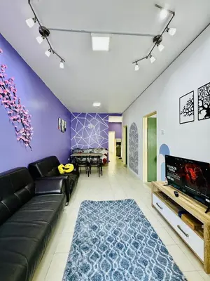 a living room with a couch and a table at AYAAN LAVENDER Homestay with PS4 Gaming and Netflix at Tanah Rata Cameron Highland in Tanah Rata