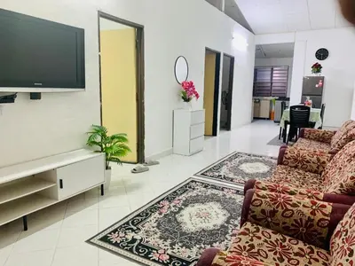 a living room with two couches and a flat screen tv at Homestay Hayyan