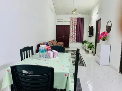 a table with a green table cloth on it in a living room at Homestay Hayyan