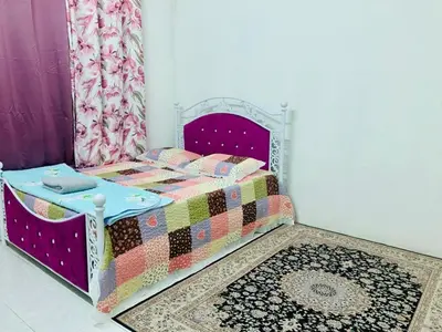 a bedroom with a bed with a purple bedspread at Homestay Hayyan