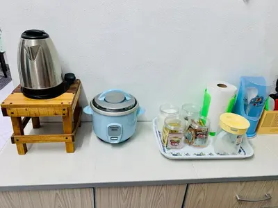 a kitchen counter with a coffee maker and jars on a table at Homestay Hayyan