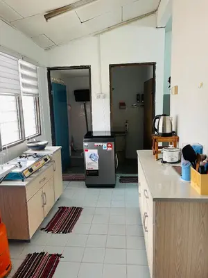 a kitchen with a refrigerator in the middle of a room at Homestay Hayyan