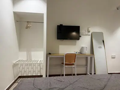a room with a desk and a tv on a wall at MR Homestay HotelStyle Room Hutan Melintang in Hutan Melintang