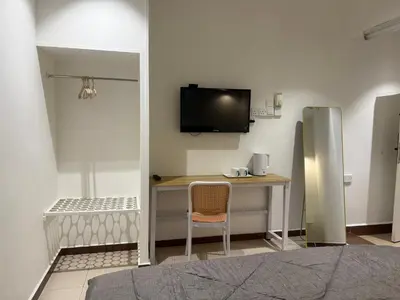 a room with a desk and a tv on the wall at MR Homestay HotelStyle Room Hutan Melintang in Hutan Melintang