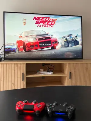 a television with two video game controllers in front of it at Ayaan Family Retreat with PS4 and Netflix in Tanah Rata
