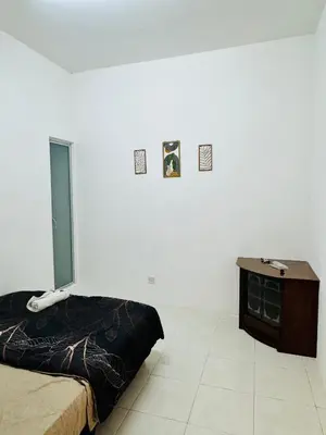 a bedroom with a bed and a table and a phone at Ayaan Family Retreat with PS4 and Netflix in Tanah Rata