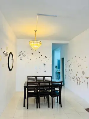 a dining room with a table and chairs and a chandelier at AYAAN HOLIDAY INN Homestay at Tanah Rata with PS4 gaming in Tanah Rata