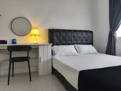 a bedroom with a bed and a desk with a mirror at Inap kluster Alamanda in Kuala Kangsar
