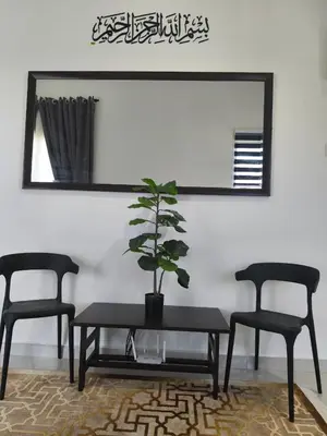 a table with a potted plant and two chairs at Inap kluster Alamanda in Kuala Kangsar