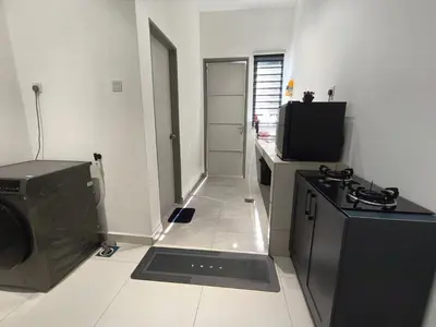 a kitchen with a washing machine and a television at Inap kluster Alamanda in Kuala Kangsar