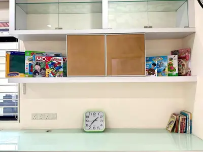 a shelf with a clock on a shelf with toys at Raja Uda Family Haven 4BR 10 Pax in Butterworth
