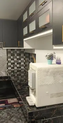 a kitchen with a counter with a white microwave at Putra Villa Homestay Ipoh in Ipoh