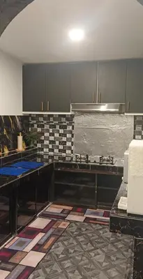 a kitchen with gray cabinets and a tile floor at Putra Villa Homestay Ipoh in Ipoh