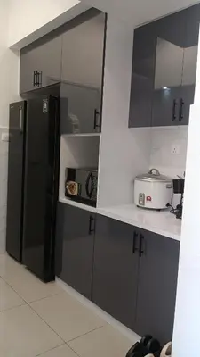 a kitchen with black and white cabinets and a refrigerator at Nuha Homestay La Casa Lunas